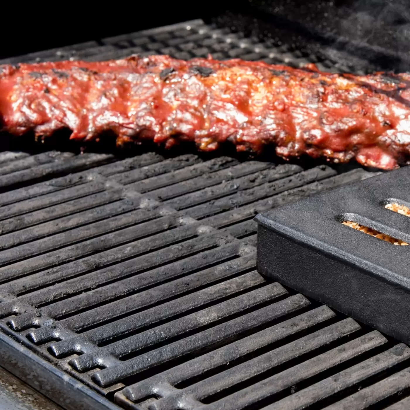 Cast iron smoker box for gas grill outlet